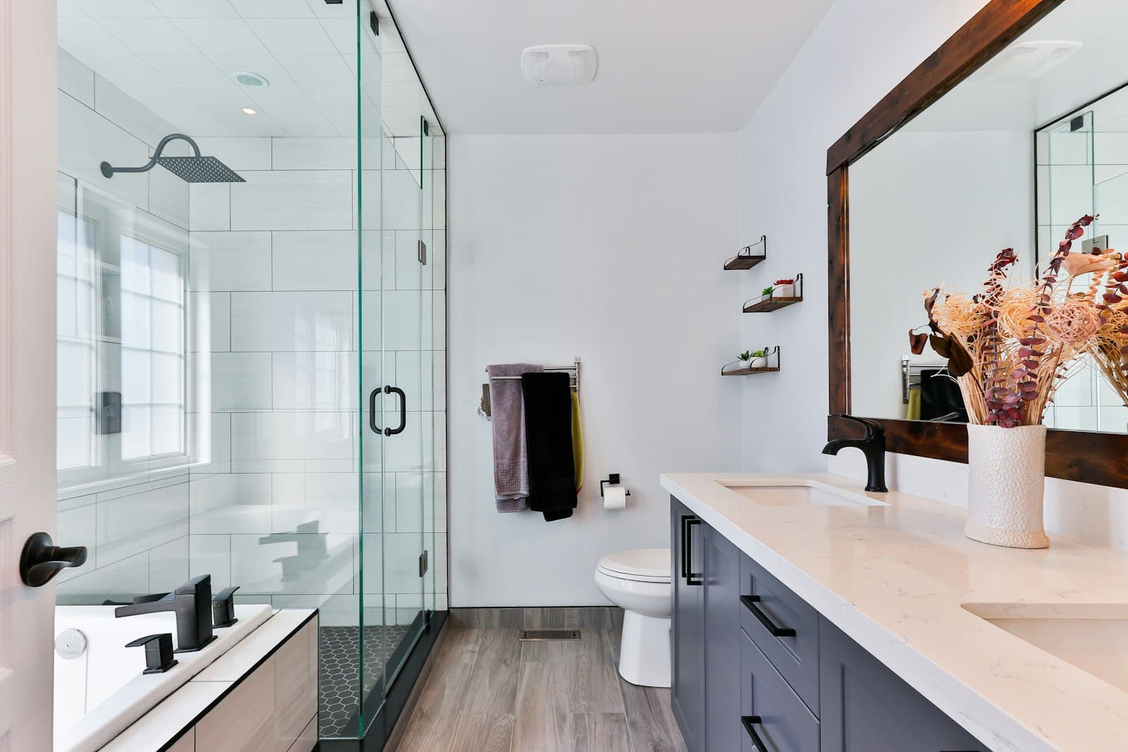 Clean tiled bathroom with Western toilet and hot water geyser at Kailasha Stays Deoghar